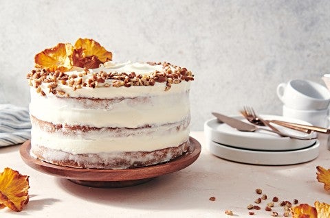 A Hummingbird Cake with a pineapple cream cheese frosting and dried pineapple and toasted nuts on top.