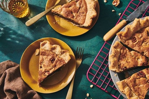Slices of Chocolate Chip Pecan Pie on plates next to the full pie