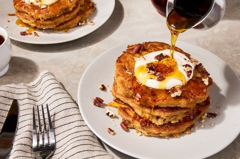 Carrot Cake Pancakes on a plate with syrup pouring over them