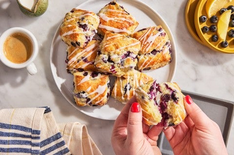 Blueberry Biscuits with Lemon Glaze on a dish with one being broken open