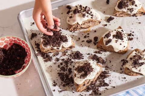 Glazed Cookies-and-Cream Scones being topped with cookie crumbles