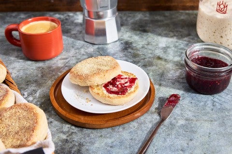 Gluten-Free Sourdough English Muffins made with Bread Flour sliced on a plate with butter and jam