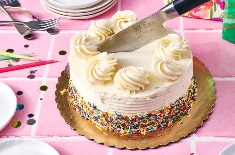 Knife being used to cut a round cake