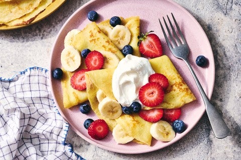 Gluten-Free Crêpes on a plate with berries and cream