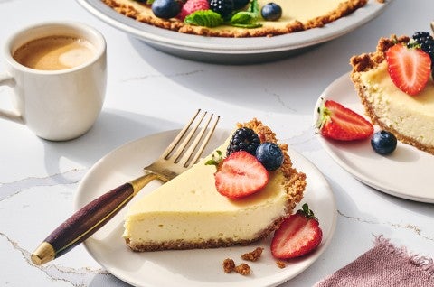 Easy Cheesecake sliced and on a plate with a cup of coffee