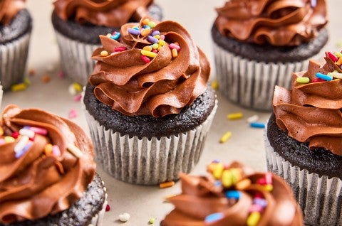 A bunch of Bake Sale Fudge Cupcakes topped with rainbow sprinkles