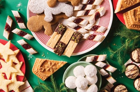 Variety of holiday cookies on a dark green background