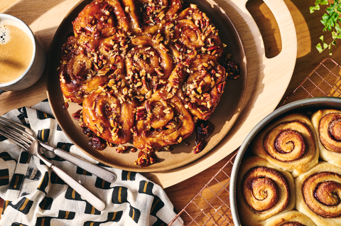 Overhead view of finished sticky buns and their unfinished counterparts.