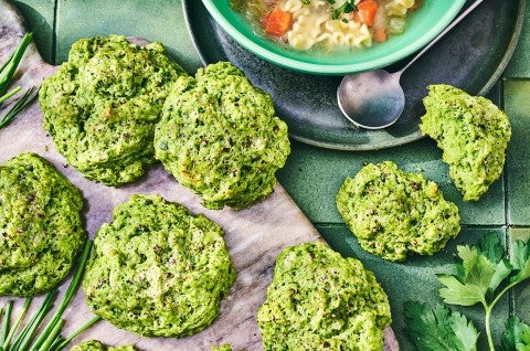 Green Goddess Herb Biscuits on cutting board with a bowl of soup in the frame.