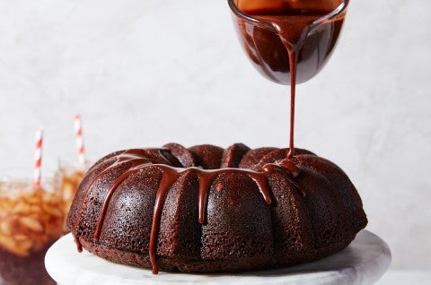 Ganache being poured on top of a Bundt cake