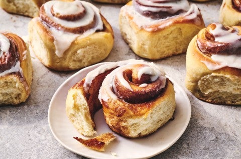 A Sourdough Cinnamon Roll on a plate accompanied by coffee.