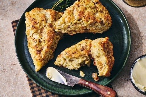 French Onion Scones on a dark plate with a butterknife