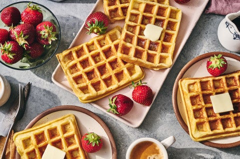 Waffles arranged on plates with fresh fruit