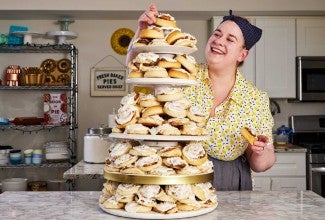 Erin placing a roll on her cinnamon roll tower