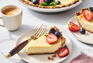 Easy Cheesecake sliced and on a plate with a cup of coffee