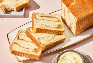 A sliced loaf of Swirled Maple Milk Bread on a serving tray
