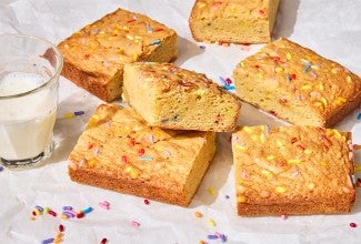 Small-Batch Birthday Cake Blondies on a counter with a glass of milk