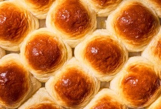 Overhead view of freshly baked dinner rolls on a tray.