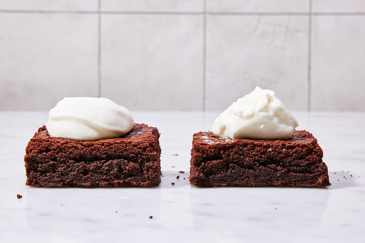 Two brownies, one with a dollop of perfectly smooth whipped cream and another with over-whipped, grainy whipped cream.