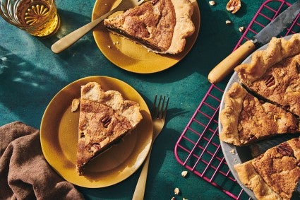Slices of Chocolate Chip Pecan Pie on plates next to the full pie