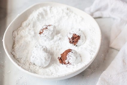 Crinkle cookie dough being tossed in confectioners' sugar