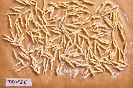 Trofie pasta shape on a parchment-line baking sheet