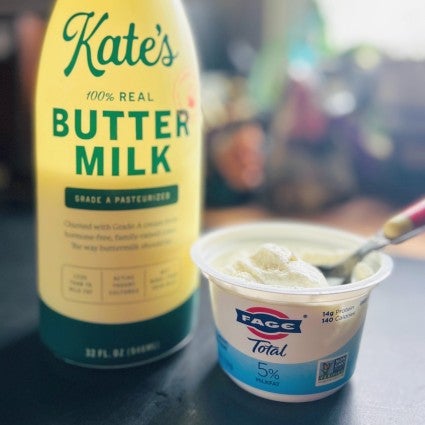 A carton of buttermilk and container of plain whole-milk yogurt sitting on a counter.