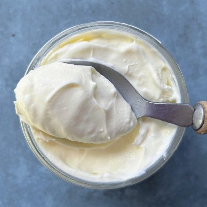 A spoonful of hommade creme fraiche showing its rich, thick texture.