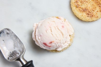 Scoop of strawberry ice cream on a round of sandwich bread to make ice cream sandwiches