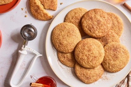 Cookie scoop next to plate of cookies