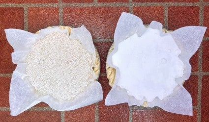 Two single pie crusts, one lined with parchment and rice, one with parchment and granulated sugar, ready for prebaking.
