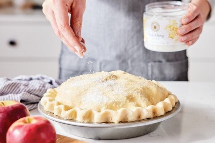 Sprinkling Sparkling Sugar on top of an unbaked apple pie
