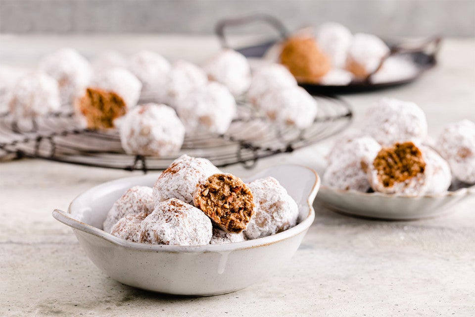 A bowl of Horchata Polvorones with some on a cooling rack in the background