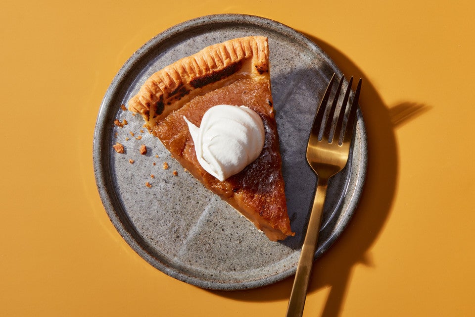 A slice of Maple Cream Pie on a plate topped with whipped cream