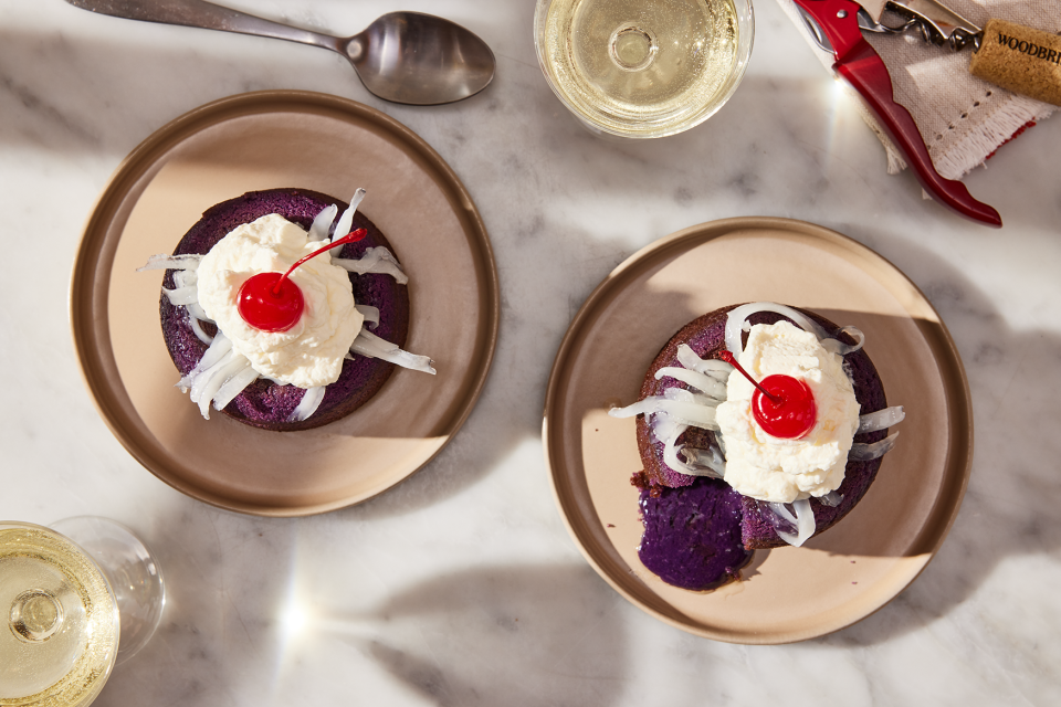 Small molten lava cakes flavored with ube and topped with whipped cream