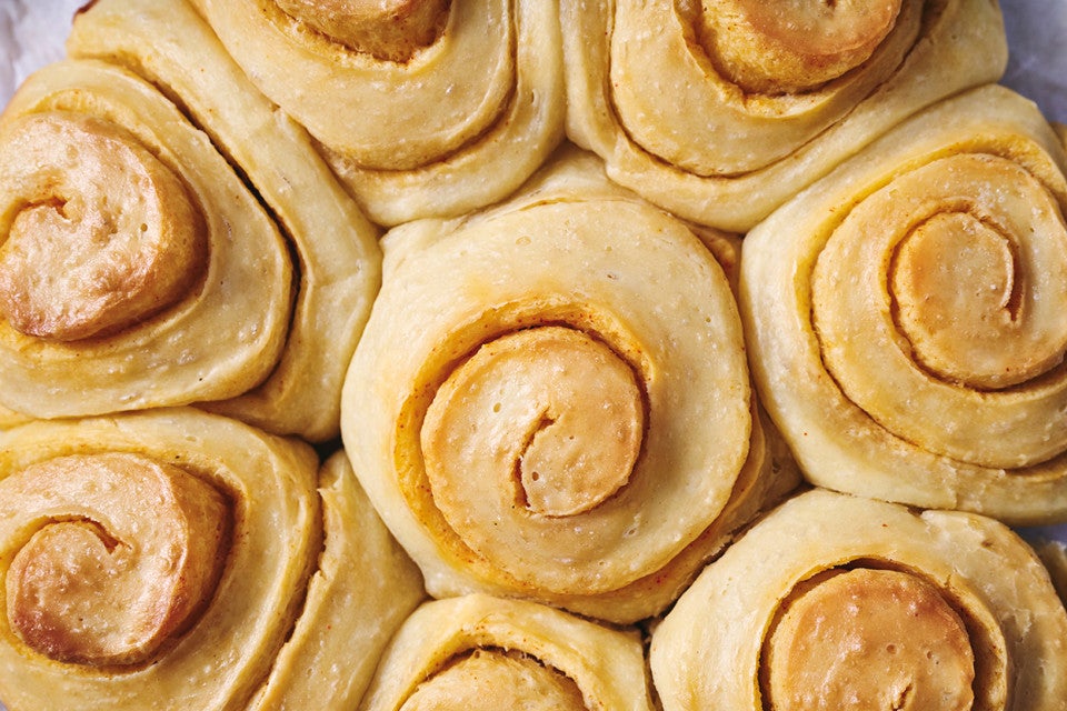 A close up overhead photo of Buttery Sourdough Buns with a swirl of paprika in them.