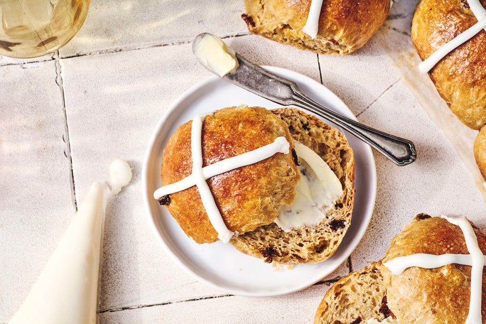 Easy Hot Cross Buns on a plate with butter