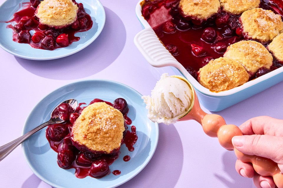 Buttermilk Biscuit Cherry Cobbler on a plate with ice cream being scooped