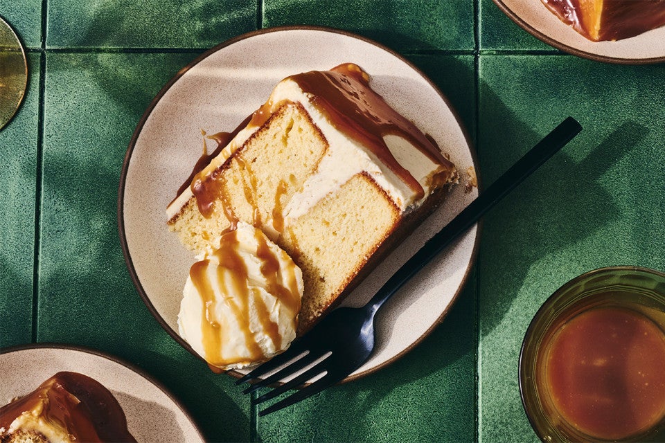 A slice of Caramel Layer Cake with Brown Butter Frosting on a plate with ice cream