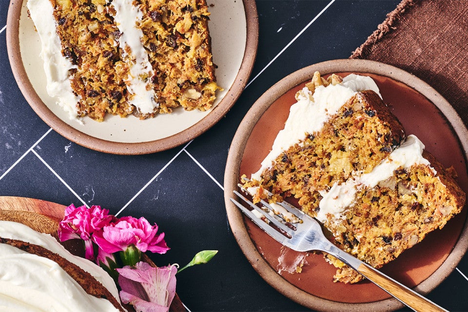 Two slices of Gluten-Free Carrot Cake with Cream Cheese Frosting on plates
