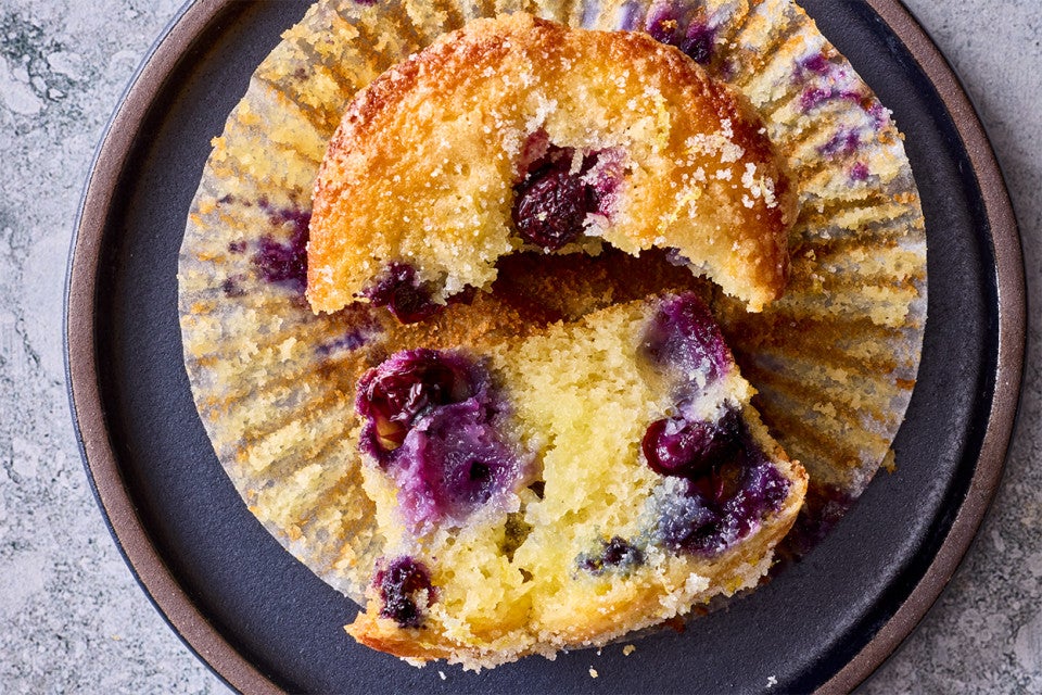 Close up of a broken Lemon Blueberry Muffin on a plate
