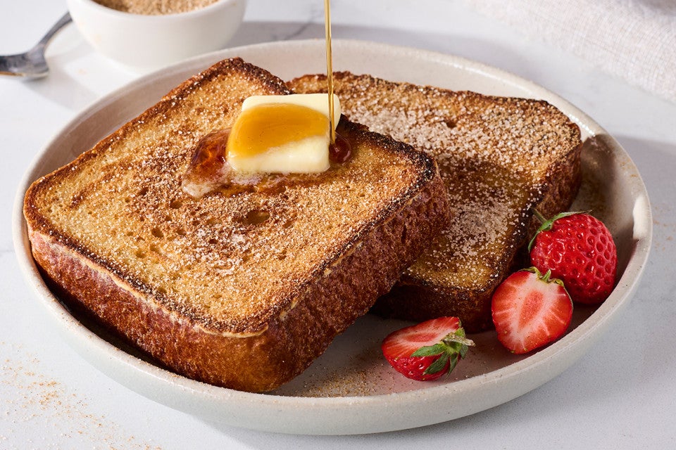 Brioche French Toast on a plate with butter and maple syrup