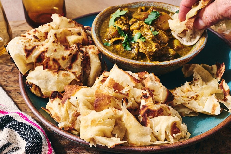 Buss Up Shut (Paratha Roti) being dipped