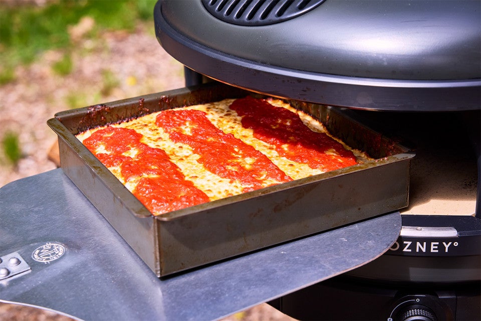 Pizza Oven Detroit Pizza coming out of the pizza oven