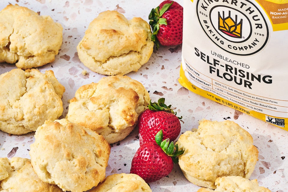 Easy Drop Biscuits on a counter with strawberries and self-rising flour