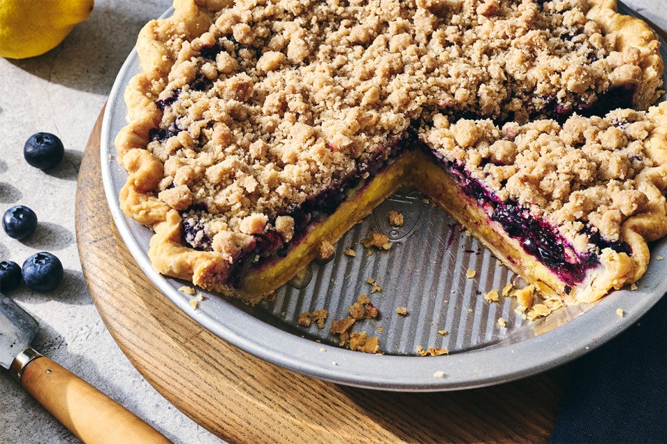 Lemon-Blueberry Streusel Pie in a pie dish with a slice removed