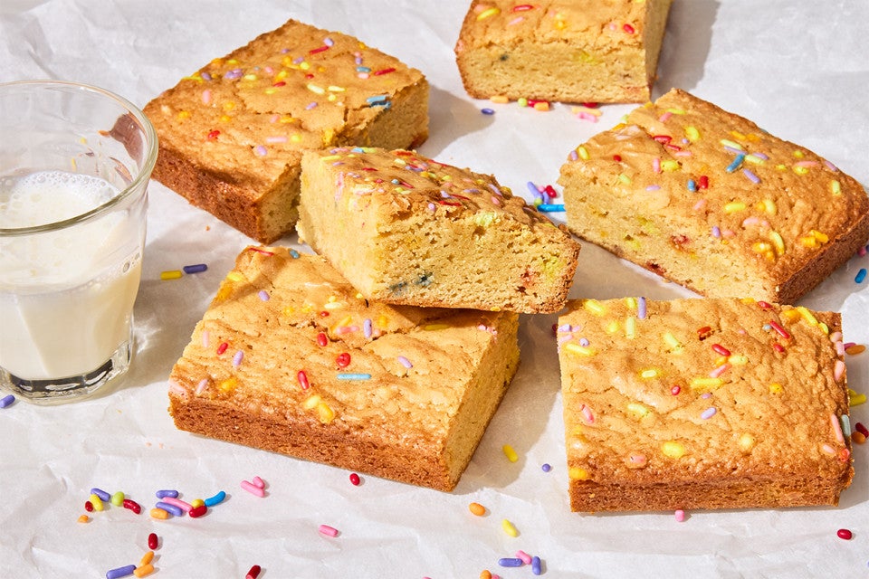 Small-Batch Birthday Cake Blondies on a counter with a glass of milk