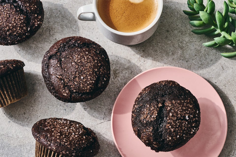 A Chocolate Breakfast Muffin on a plate with a cup of coffee