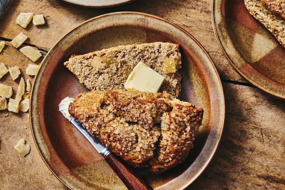 A Ginger Scone cut in-half and with a pad of butter
