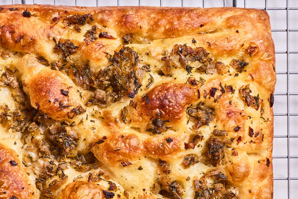 Detail of the corner of a stuffing focaccia showing integrated ingredients and browning of the bake.